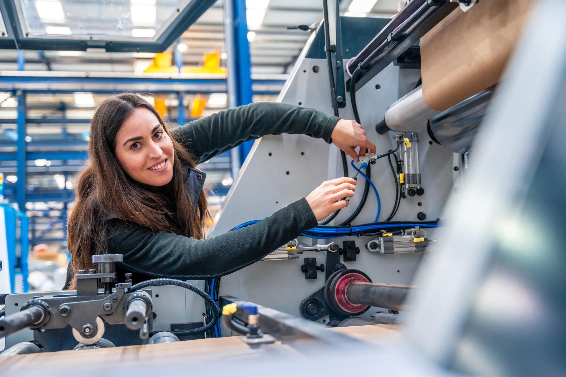 Engineer repairing a cnc machine in a modern logistic factory